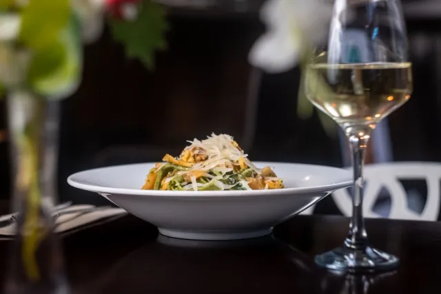 Plato de pasta y copa de vino blanco — fotografía gastronómica para un restaurante en Barcelona