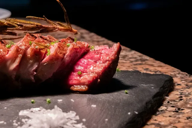 Corte de carne jugosa fileteada sobre piedra — fotografía gastronómica para un restaurante en Barcelona
