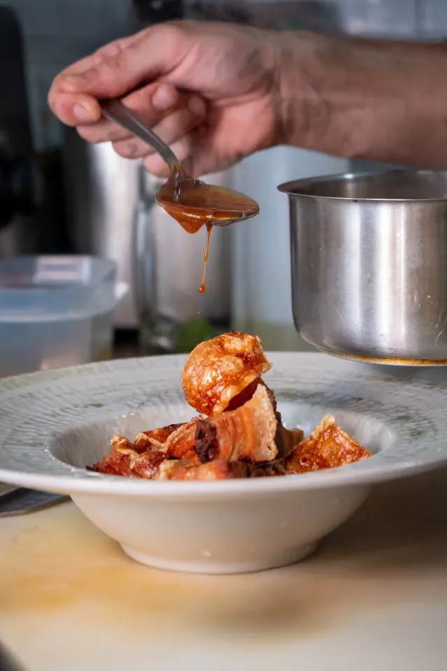 Chef napando un plato con salsa en el pase — fotografía de cocina para un restaurante en Barcelona